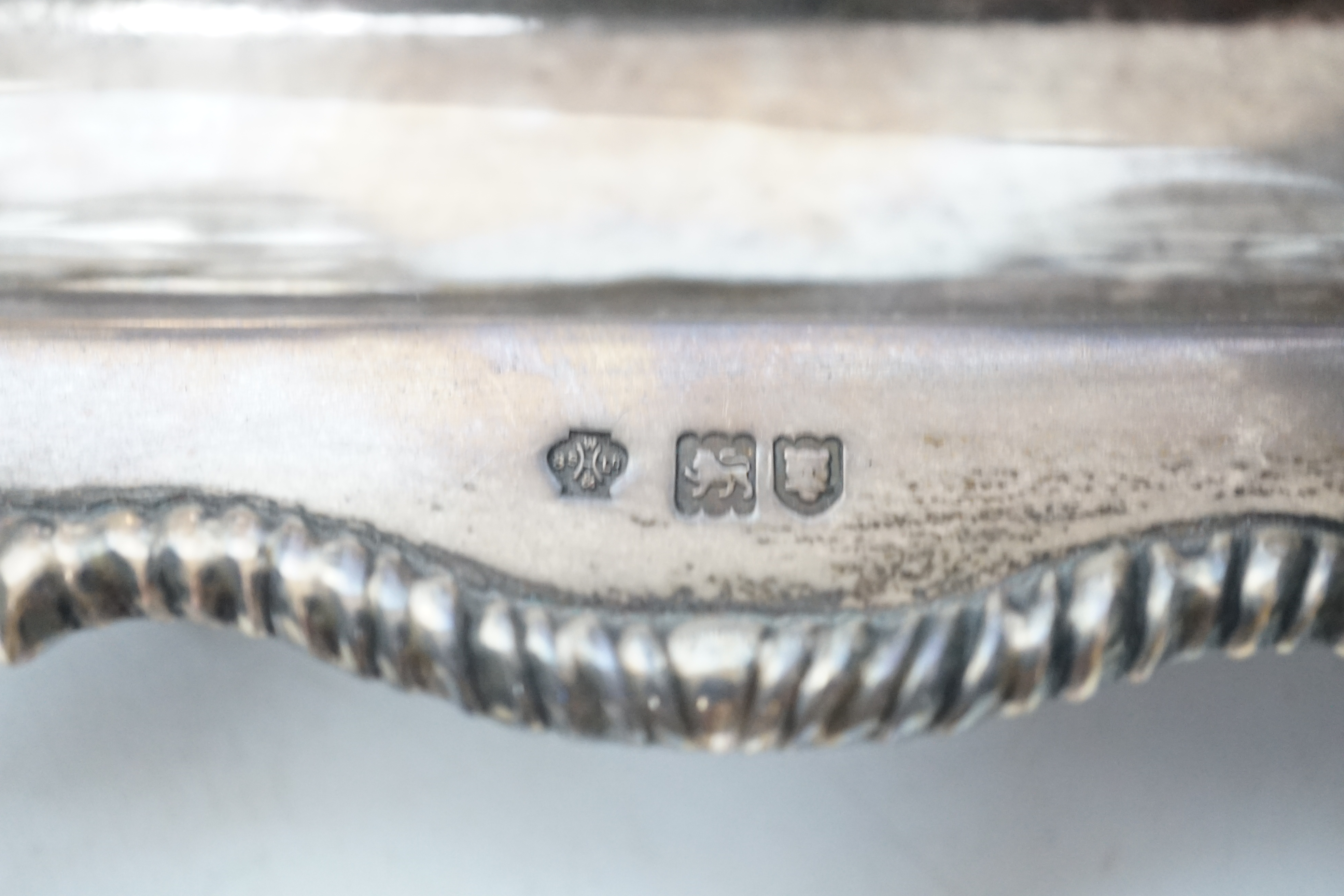 An Edwardian silver rectangular inkstand with pierced three quarter gallery and two mounted cut glass wells, William Hutton & Sons Ltd, London, 1905, 22.3cm and a George V silver mounted circular photograph frame.